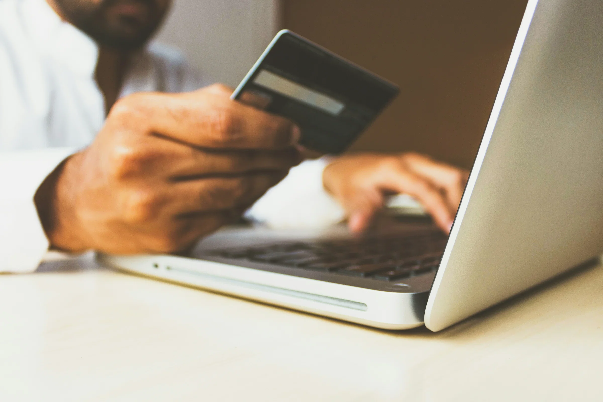Homeowner paying a deposit by card on a laptop, card in hand